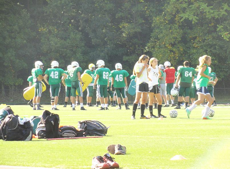 The girls soccer and football teams share Joe Poli field recently during practice sessions for both squads.