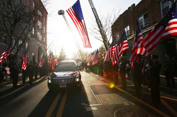 The+hearse+comes+down+the+center+of+Westwood+surrounded+by+the+343+American+flags+that+the+FDNY+provided.+
