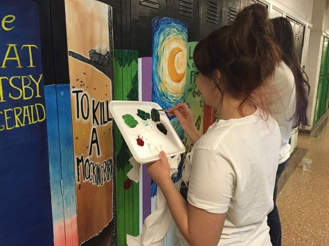 Students work on a book mural on the lockers upstairs.