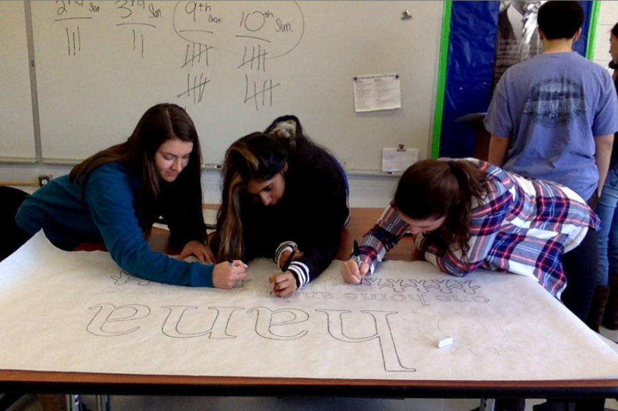 (From left to right) Julianna Masseria, Kajal Ramrup, and Rebecca Fontana work on a banner for OHANA 