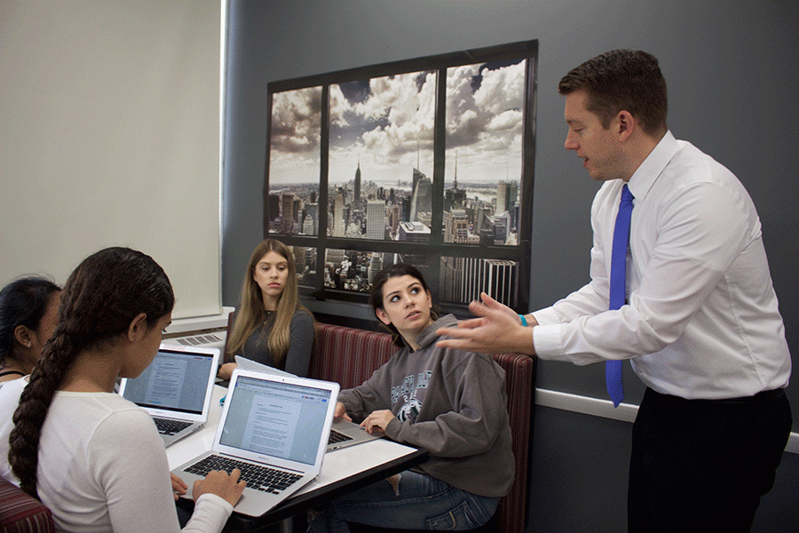 Mr. Matt Morone helps his students work on their newsroom project as a part of his open classroom style of teaching.