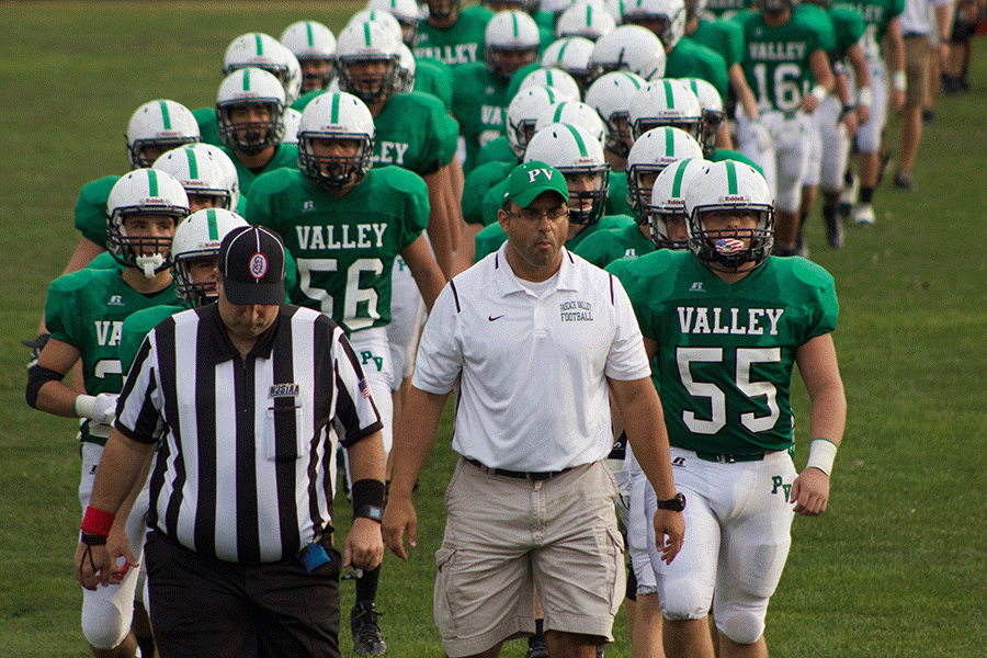 Len Cusumano, PVs new head coach, leading the Indians on to the field against River Dell in his first game.