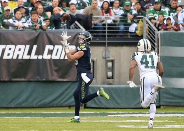 Seattle Seahawks rookie wide receiver Tanner McEvoy (in blue) hauls in a 42 yard touchdown for his first career catch. 