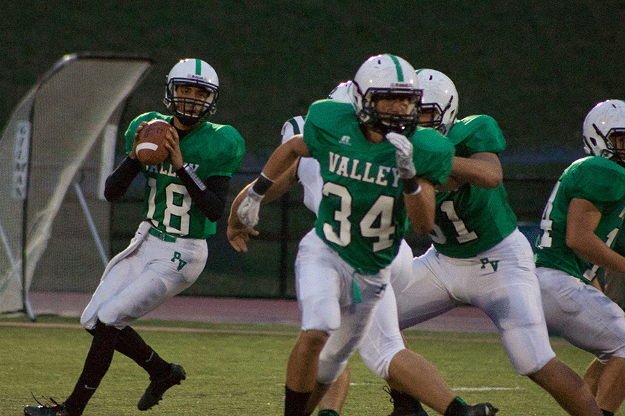 Quarterback Joe Campagna (18) getting ready to throw, and fulback Josh Tillis (34) running a route.