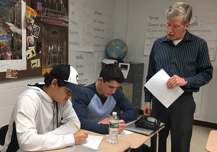 Señor Lewis helps Garrett Ben-Yishay and Tommy Chiellini with their worksheets.