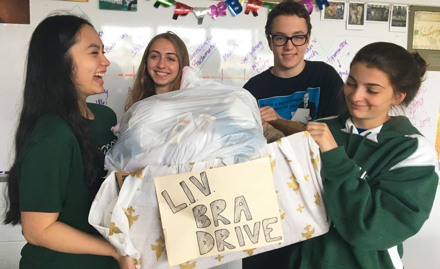 Bianca Belmonte, Julia Guskind, Aidan McBride, and Sam Nicklas hold up their bra donations.