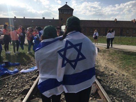 Ally Botwinick and Julia Ganbarg with the Israel flag at Birkenau. They recently went on a trip to participate in March of the Living. 