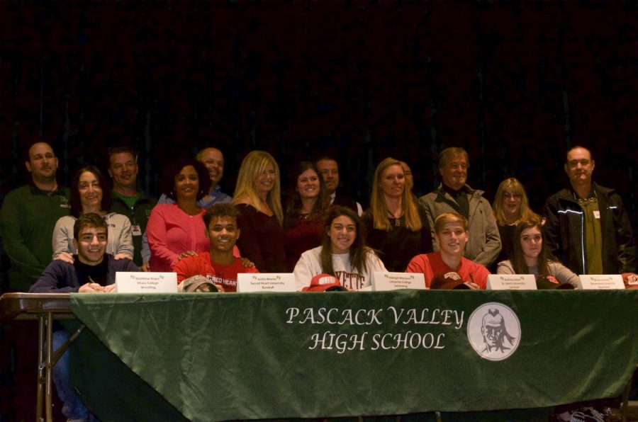 Matt Beyer, Justin Martin, Haleigh Marzano, Zach Olson, and Brianna Smith pose, along with parents and coaches. These five student-athletes took part in the National Signing Day ceremony on Wednesday in the Pascack Valley auditorium. 