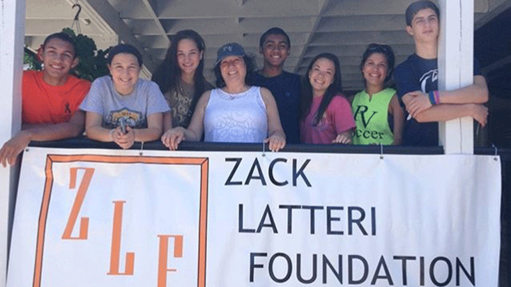 (From left) Will Morris, Tiana Giovatto, Lily Ochoa, Sharon Latteri, Rahul Nair, Megan Garrett, Lauren Martinez and Andrew Tateossian hold up a banner representing the Zack Latteri Foundation. The ZLF has continued in Pascack Valley after the class of 2018 has graduated.