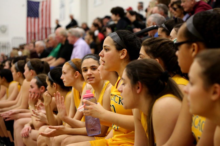 Pascack Valley girls basketball players watch the game from the bench. The majority of the Indians spend most of their time on the sideline, but many embrace their role as a team leader and a mentor. 