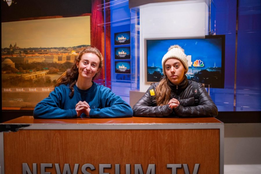 Editors in chief Rachel Cohen and Katie Mullaney sit at a news desk at the Newseum.