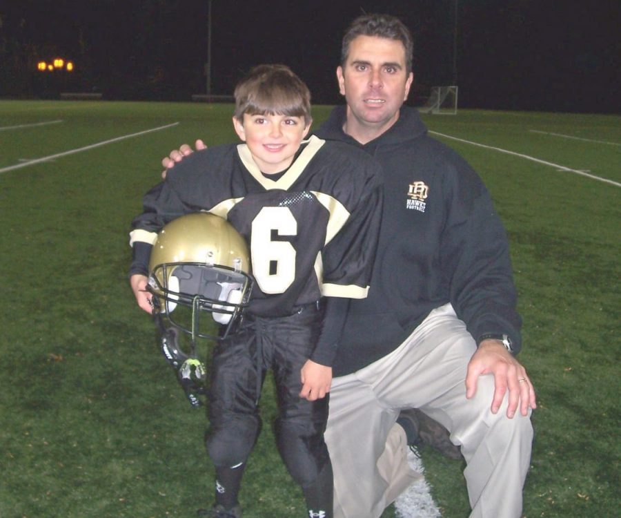 Glenn deMarrais posing with his son, who played junior football for River Dell. DeMarrais coached high school sports for almost 20 years before coaching his sons in Junior Football and Little League Baseball.