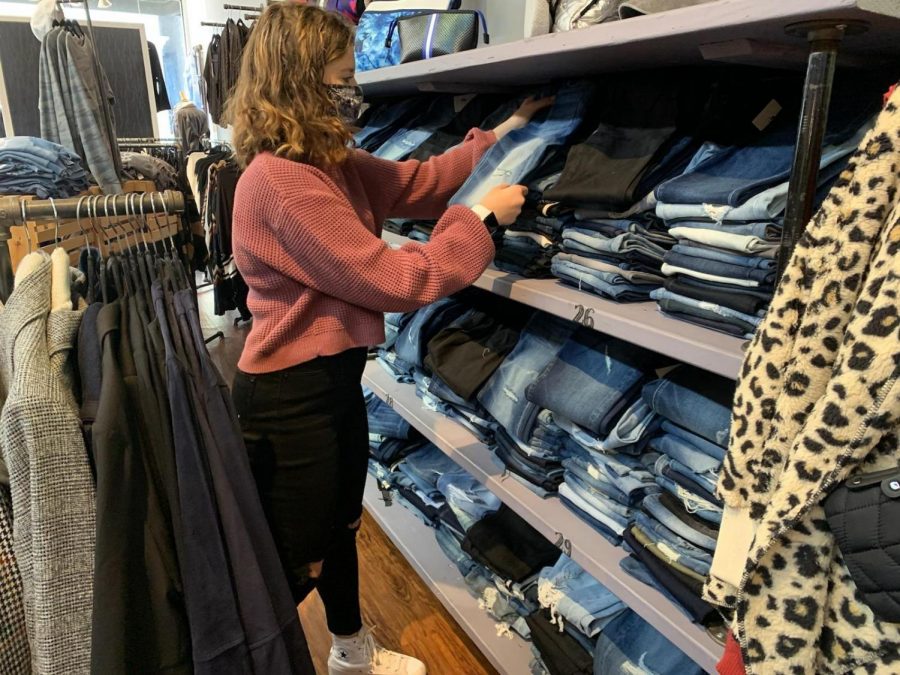 Senior Toby Shapiro interns at Threads, in Westwood. One of her responsibilities is to organize clothes on the shelves.