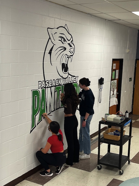 Students work to finish the final touches of the Panthers mural in the picture above.