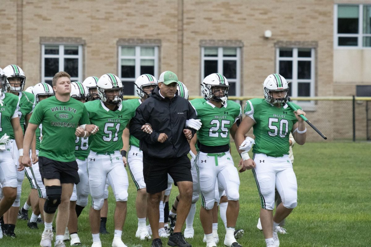 Coach Cusamano and the team walk out of the school and to the field