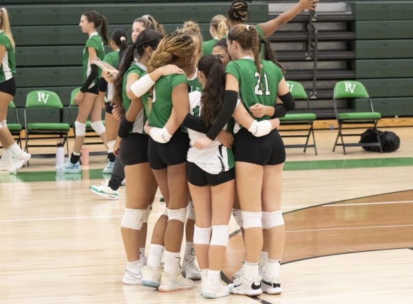 The volleyball team huddles.