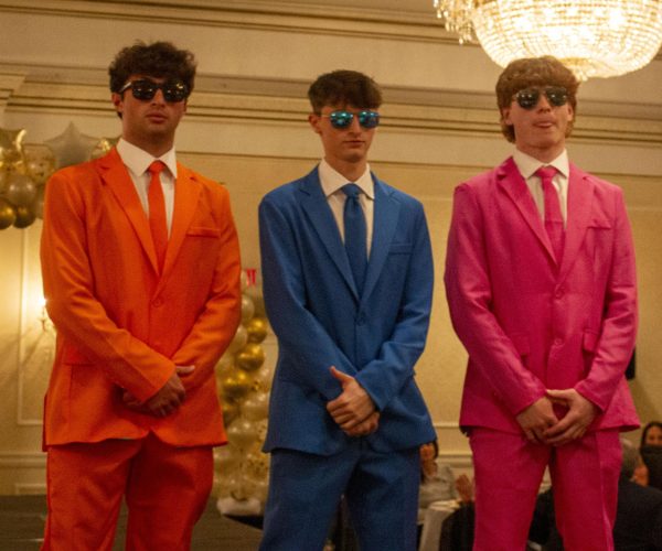 Zach Martucci, Gary Arons, and Ben Roman dress up in orange, blue, and pink