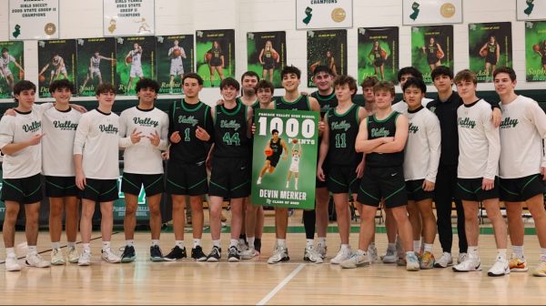 Senior guard Devin Merker celebrates scoring his 1,000th career point with teammates during Tuesday night's game against Bergen Tech