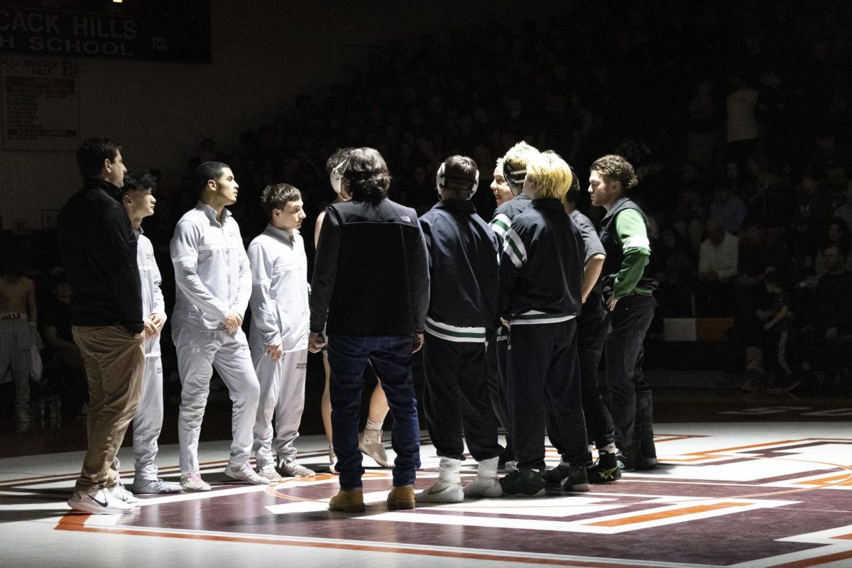 Valley and Hills' wrestling captains meet in the middle of the mat prior to the match on Friday night